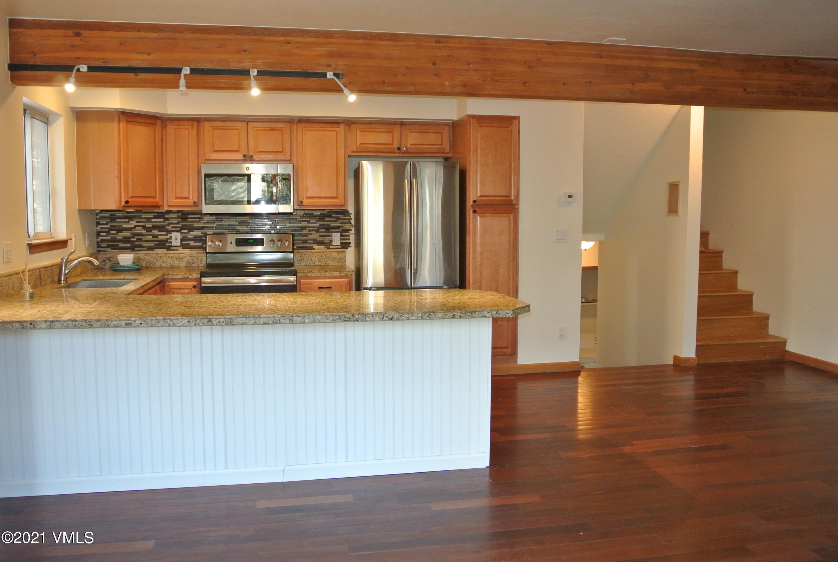 170 Eagle Road, Unit C Avon, CO 81620 - Photo 5 of 16 a kitchen with stainless steel appliances granite countertop a refrigerator a stove and a wooden floors