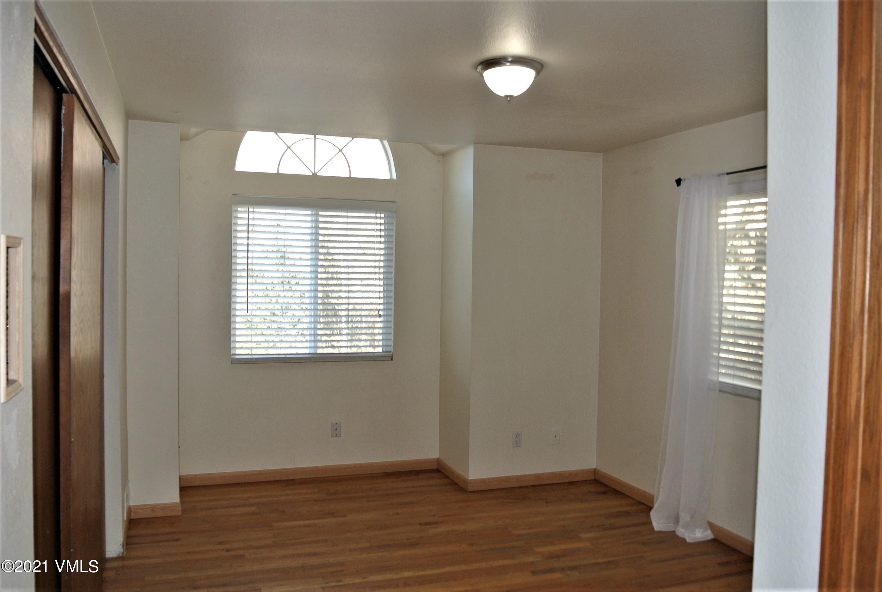 170 Eagle Road, Unit C Avon, CO 81620 - Photo 6 of 16 an empty room with wooden floor and windows