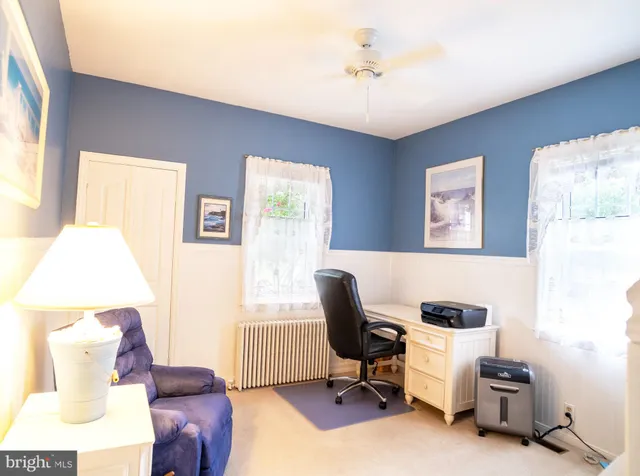 a view of a workspace with furniture and a window