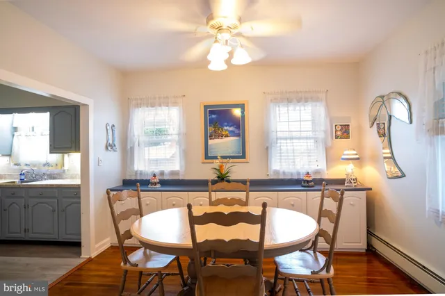 a dining room with wooden floor a chandelier a glass table and chairs