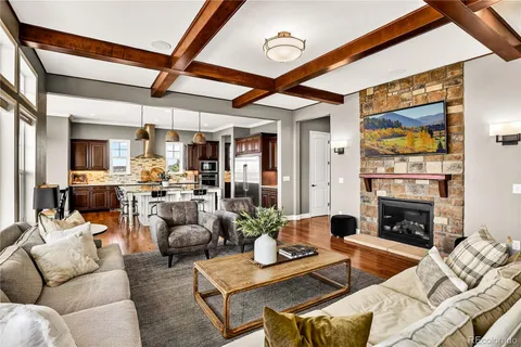 a dining room with wooden floor a chandelier a glass table and chairs
