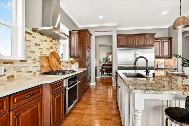 a kitchen with stainless steel appliances granite countertop a sink stove and cabinets
