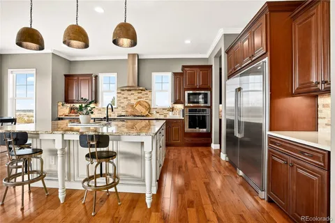 a kitchen with stainless steel appliances kitchen island granite countertop a microwave a stove and a refrigerator