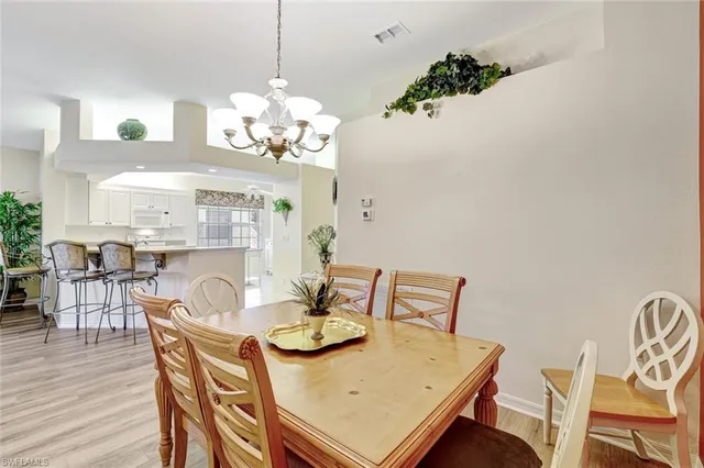 a dining room with furniture a chandelier and wooden floor