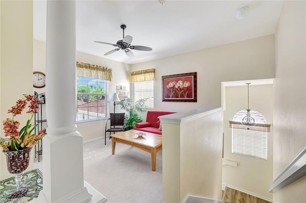 10910 Santa Margherita Road, Unit 204 Estero, FL 34135 - Photo 11 of 42 Living area featuring ornate columns, light carpet, and a ceiling fan
