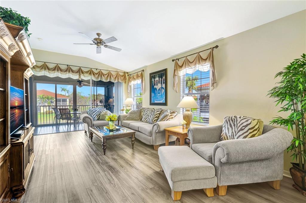 10910 Santa Margherita Road, Unit 204 Estero, FL 34135 - Photo 2 of 42 Living area featuring vaulted ceiling, wood finished floors, and a ceiling fan