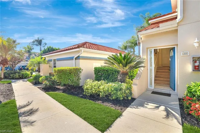 a dining room with furniture potted plants and wooden floor