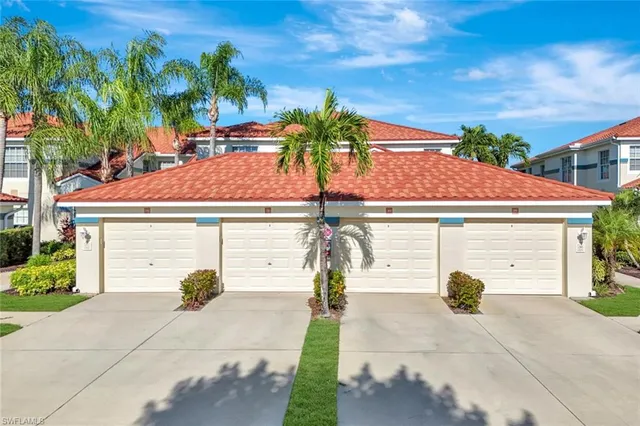 a front view of a house with a yard and potted plants
