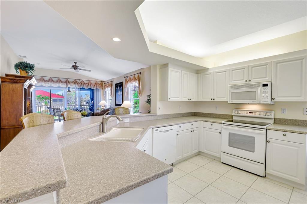 10910 Santa Margherita Road, Unit 204 Estero, FL 34135 - Photo 42 of 42 Kitchen featuring white appliances, a peninsula, white cabinetry, open floor plan, and recessed lighting