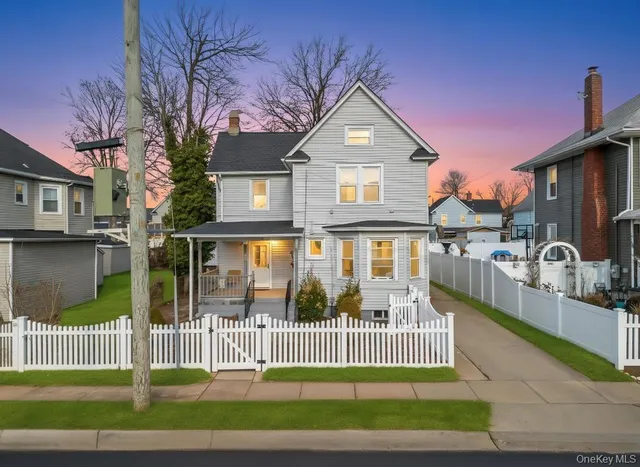 a front view of a house with a garden and plants