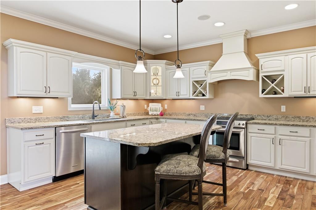 280 Sienna Trail Venetia, PA 15367 - Photo 16 of 37 a kitchen with stainless steel appliances granite countertop a stove a sink dishwasher and white cabinets with wooden floor