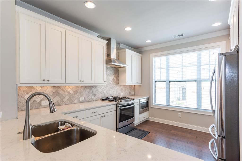 5247 Cresslyn Ridge Alpharetta, GA 30005 - Photo 14 of 38 a kitchen with stainless steel appliances granite countertop a sink dishwasher a stove and a refrigerator with wooden floor