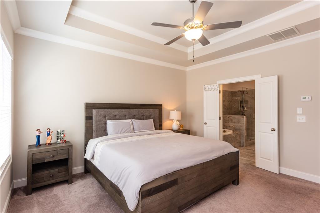 5247 Cresslyn Ridge Alpharetta, GA 30005 - Photo 25 of 38 a bedroom with a bed and a chandelier