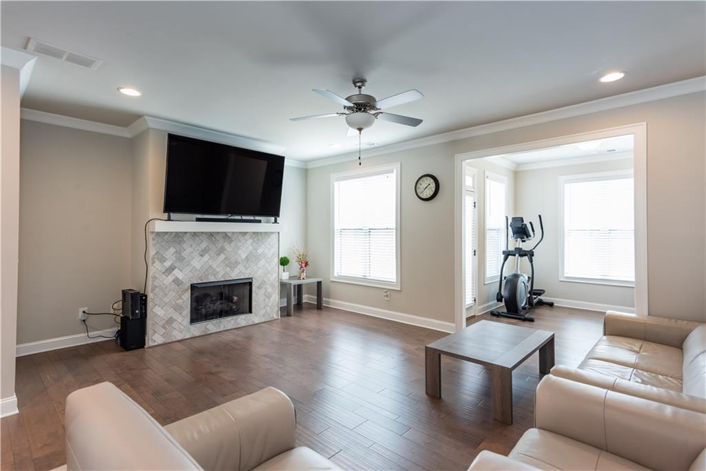 5247 Cresslyn Ridge Alpharetta, GA 30005 - Photo 6 of 38 a living room with furniture a fireplace and a flat screen tv