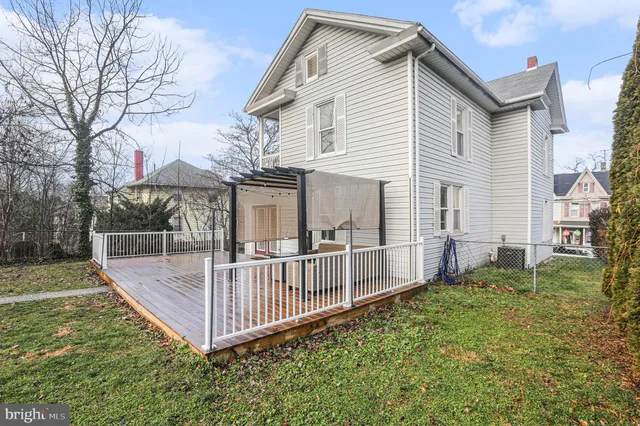 a view of a house with a yard and a wooden deck