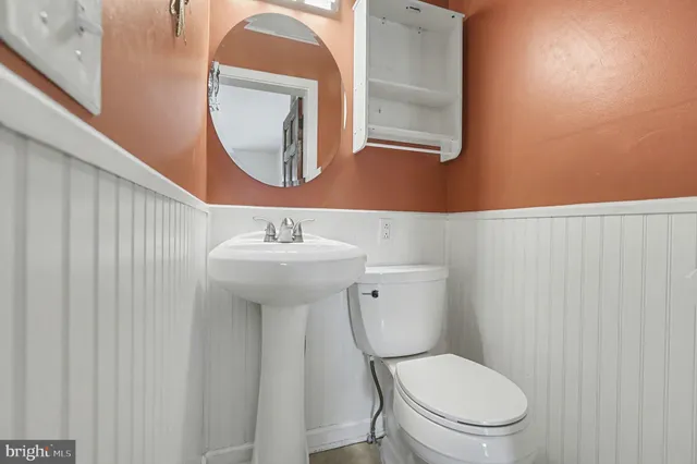 a white toilet sitting next to a bathroom sink