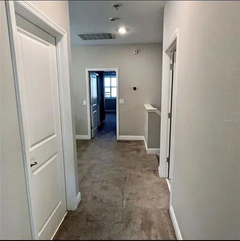 a view of a hallway with wooden shelves