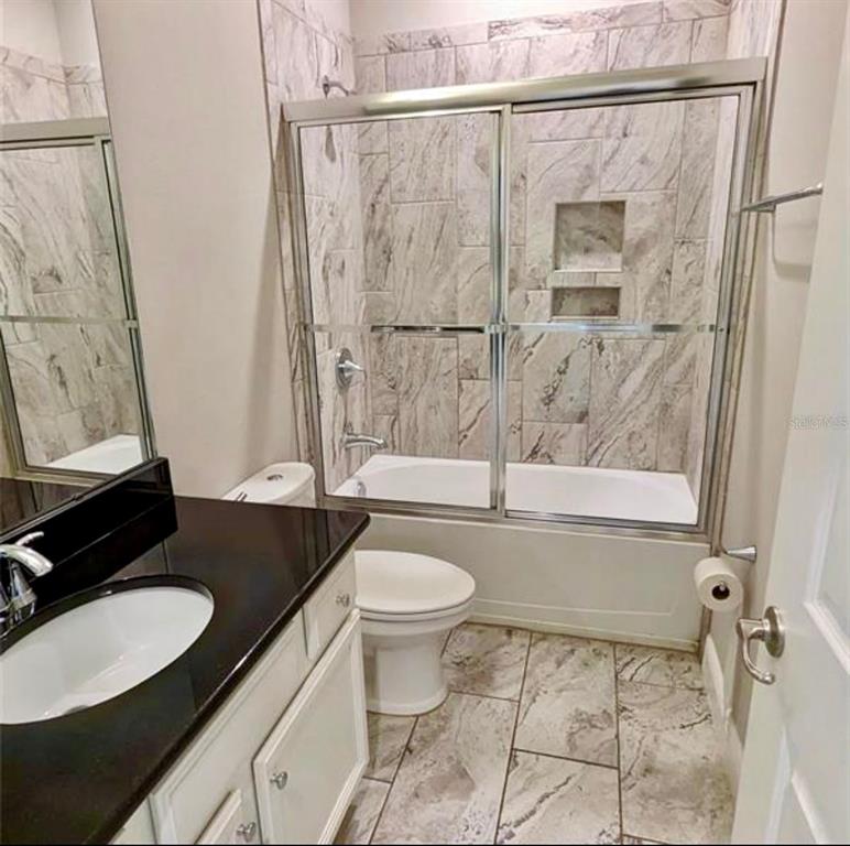 8582 Powder Ridge Trail Windermere, FL 34786 - Photo 13 of 37 a bathroom with a granite countertop sink toilet and shower