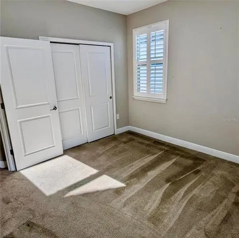 a view of a room with a white bed & cabinets
