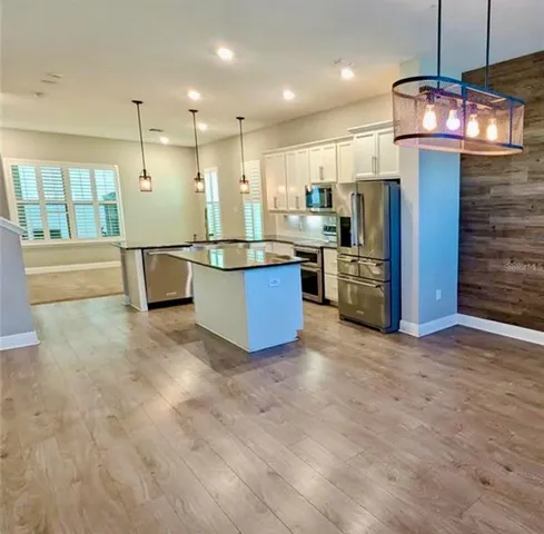 a view of kitchen with stainless steel appliances refrigerator stove microwave and cabinets