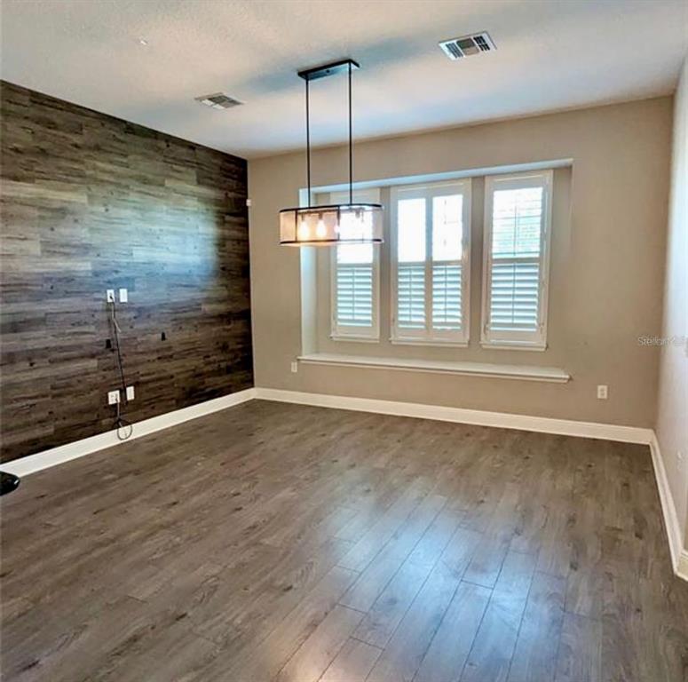 8582 Powder Ridge Trail Windermere, FL 34786 - Photo 7 of 37 an empty room with wooden floor and windows