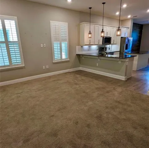 a view of kitchen with kitchen island a sink wooden floor and a counter top space