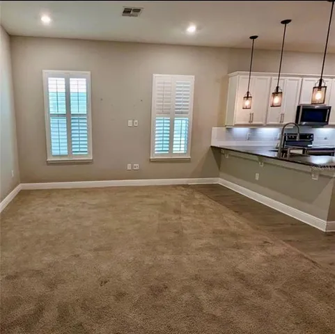 a kitchen with kitchen island a sink a stove and a window