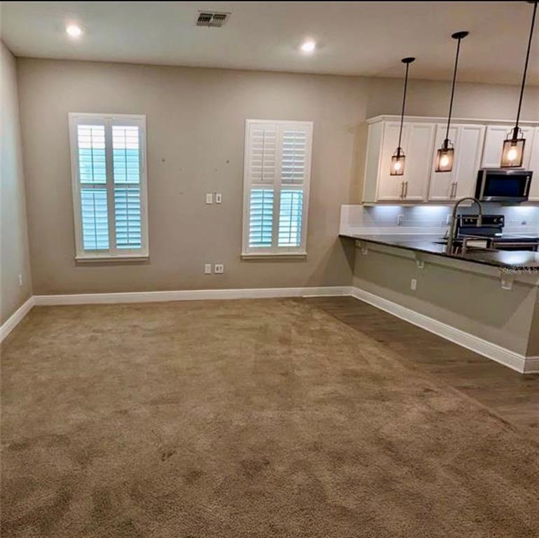 8582 Powder Ridge Trail Windermere, FL 34786 - Photo 9 of 37 a kitchen with kitchen island a sink a stove and a window