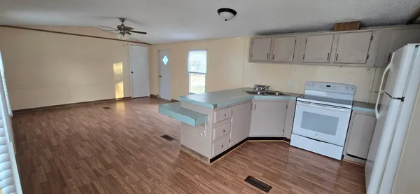 a kitchen with granite countertop white cabinets and white appliances