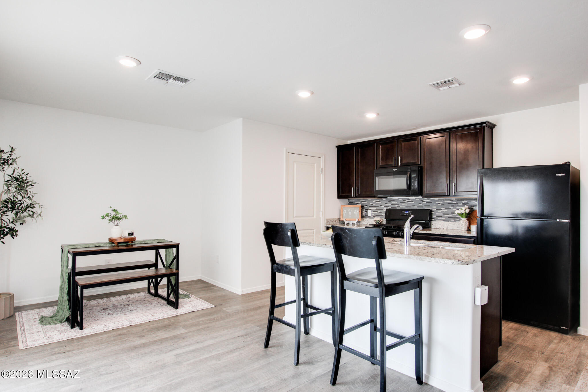 5987 South Antrim Loop Tucson, AZ 85706 - Photo 11 of 34 a kitchen with a table chairs refrigerator and microwave