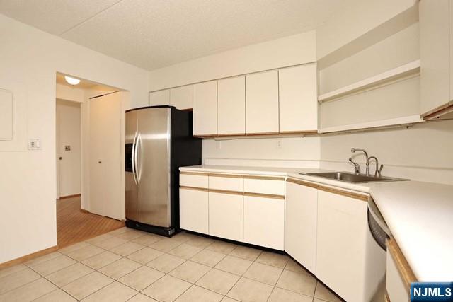 1055 River, Unit 506 Edgewater, NJ 07020 - Photo 8 of 25 a kitchen with stainless steel appliances granite countertop a refrigerator a sink and white cabinets