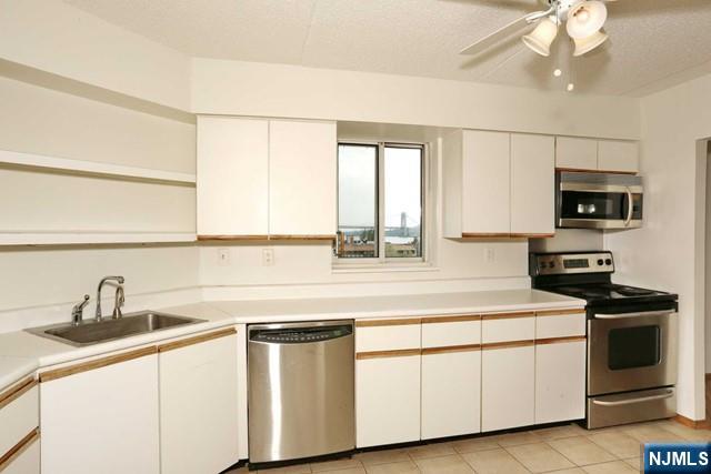 1055 River, Unit 506 Edgewater, NJ 07020 - Photo 9 of 25 a kitchen with stainless steel appliances granite countertop white cabinets a sink and a oven