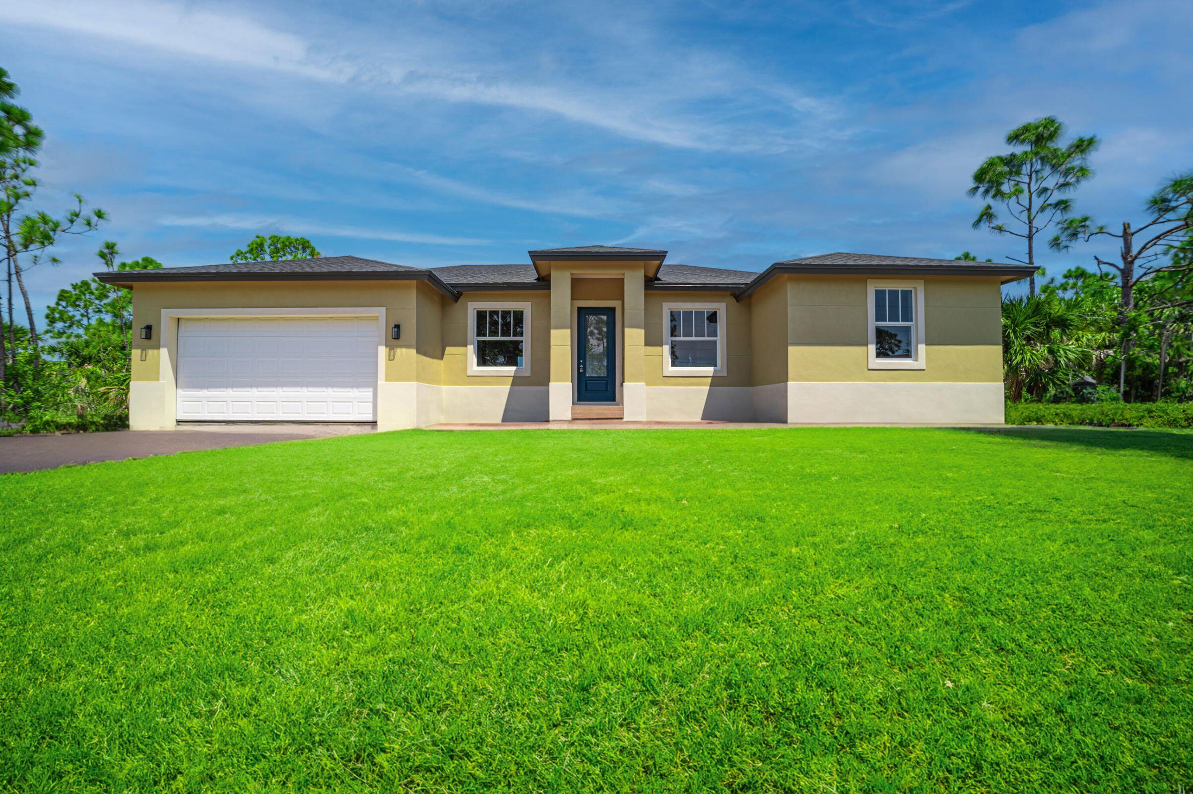 a front view of a house with a yard and trees