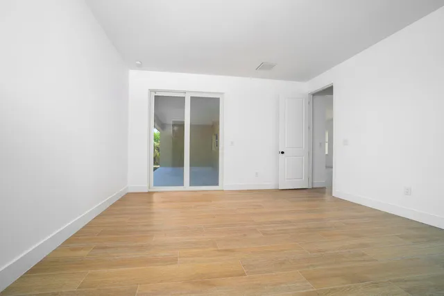 a view of an empty room with wooden floor