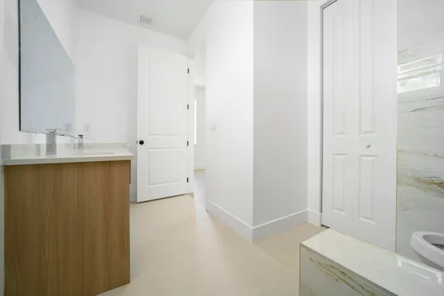 a bathroom with a granite countertop sink toilet and shower