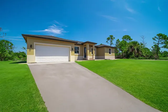 a front view of a house with a yard and garage