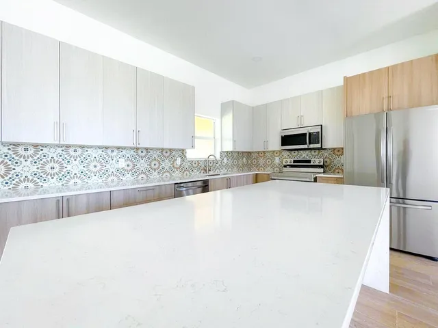 a kitchen with stainless steel appliances a refrigerator a sink a stove a microwave and cabinets