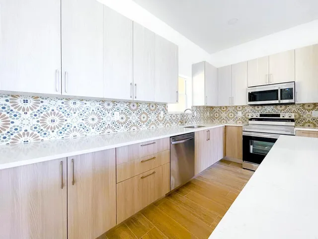 a kitchen with granite countertop white cabinets and stainless steel appliances