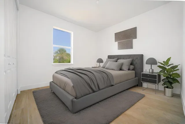 a bedroom with a bed lamp and a potted plant