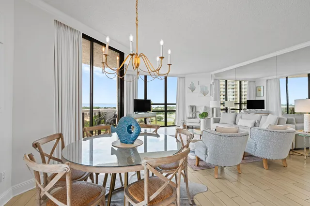 a dining room with furniture a chandelier and wooden floor