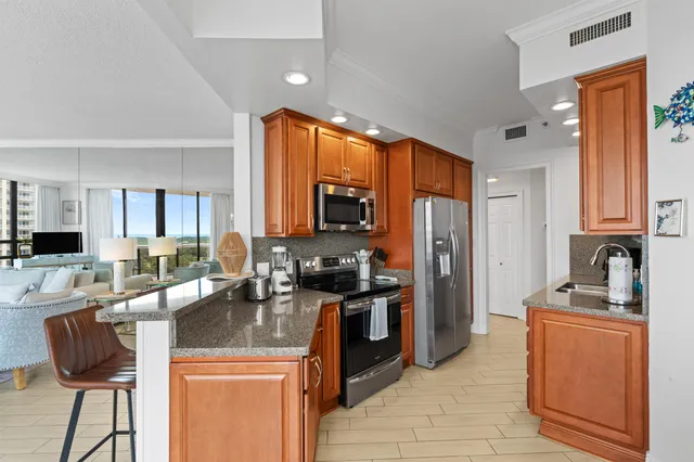 a kitchen with stainless steel appliances granite countertop a sink stove and refrigerator