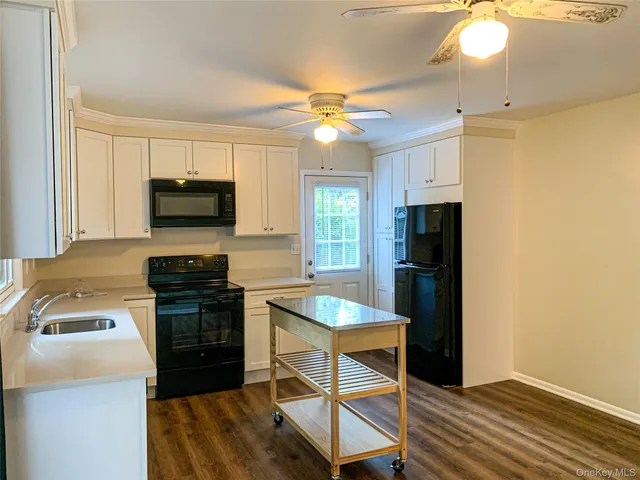 a kitchen with a refrigerator a stove a microwave oven with cabinets and wooden floor