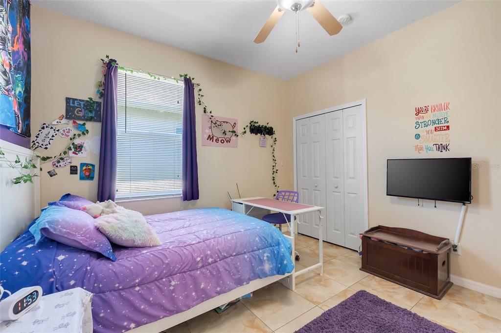 10232 Andover Point Circle Orlando, FL 32825 - Photo 17 of 33 a bedroom with a bed and a flat screen tv