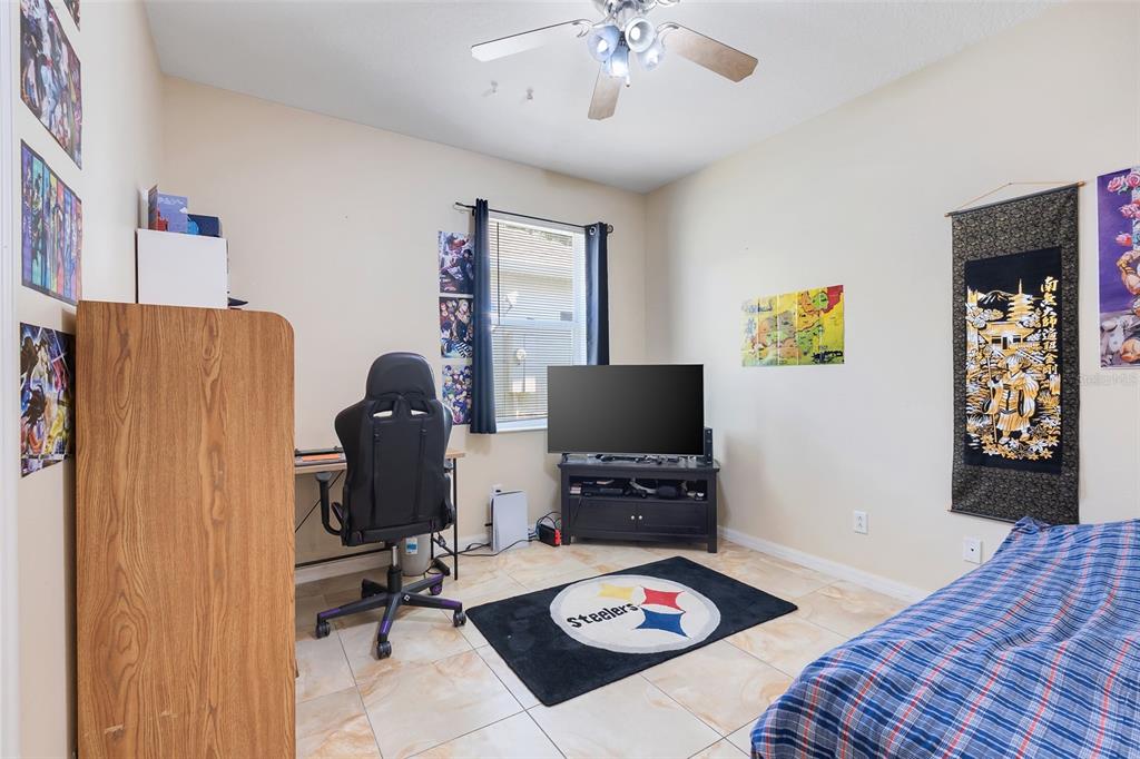 10232 Andover Point Circle Orlando, FL 32825 - Photo 20 of 33 a bedroom with a bed and a computer on a desk next to a window