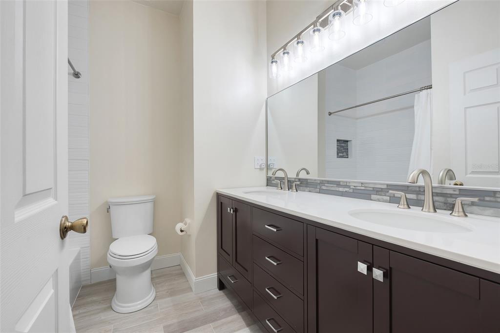 10232 Andover Point Circle Orlando, FL 32825 - Photo 21 of 33 a bathroom with a double vanity sink and a toilet