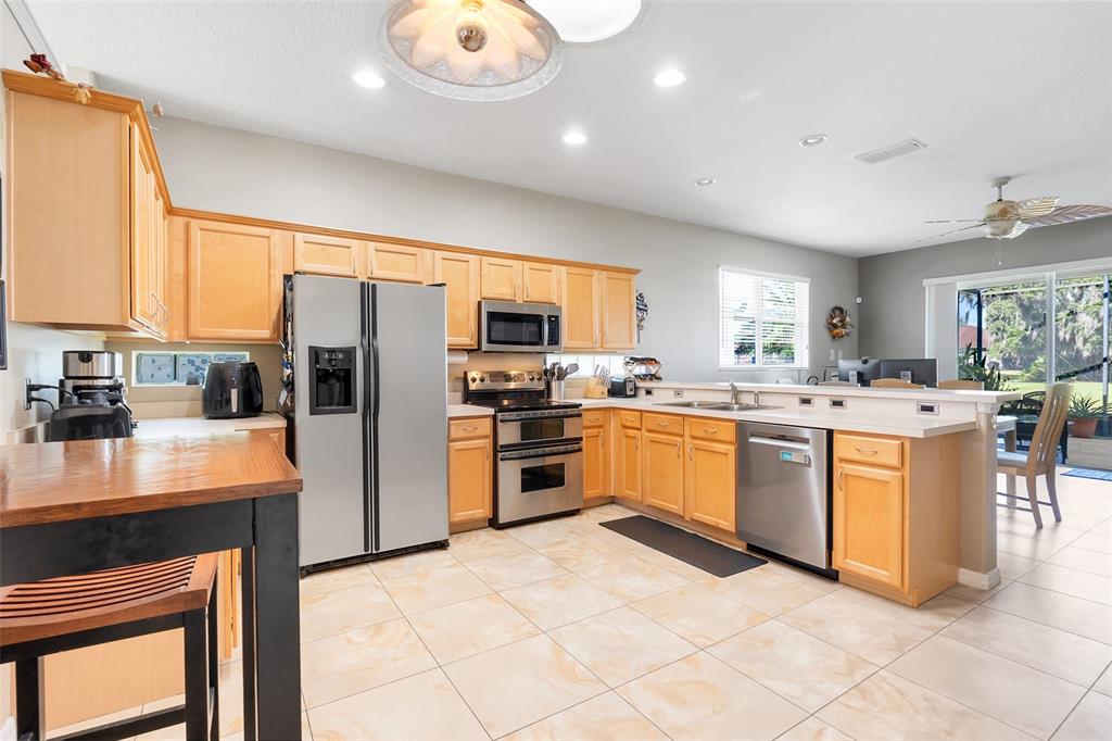 10232 Andover Point Circle Orlando, FL 32825 - Photo 6 of 33 a kitchen with stainless steel appliances granite countertop a stove refrigerator sink and dishwasher with wooden floor