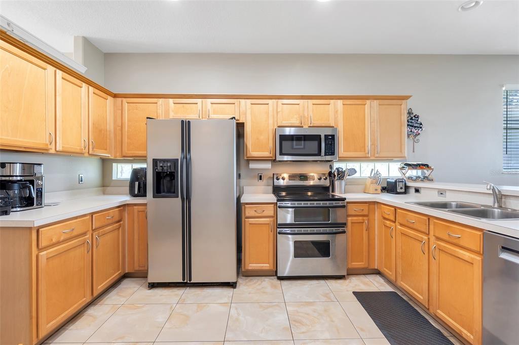 10232 Andover Point Circle Orlando, FL 32825 - Photo 8 of 33 a kitchen with stainless steel appliances granite countertop a refrigerator and a stove top oven