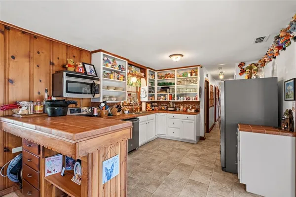 a kitchen with a sink refrigerator and microwave