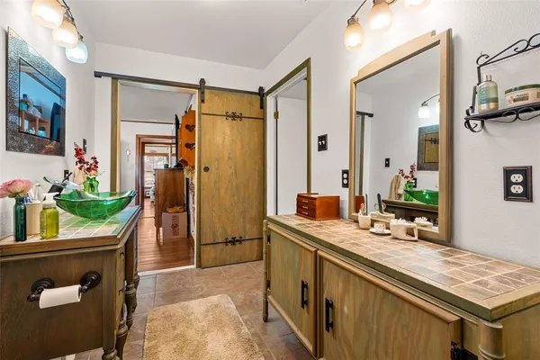 a bathroom with a granite countertop sink a mirror and a shower