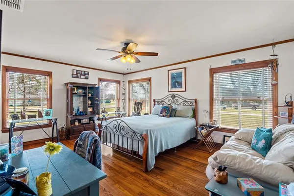 a bedroom with 2 bed couch and a large window